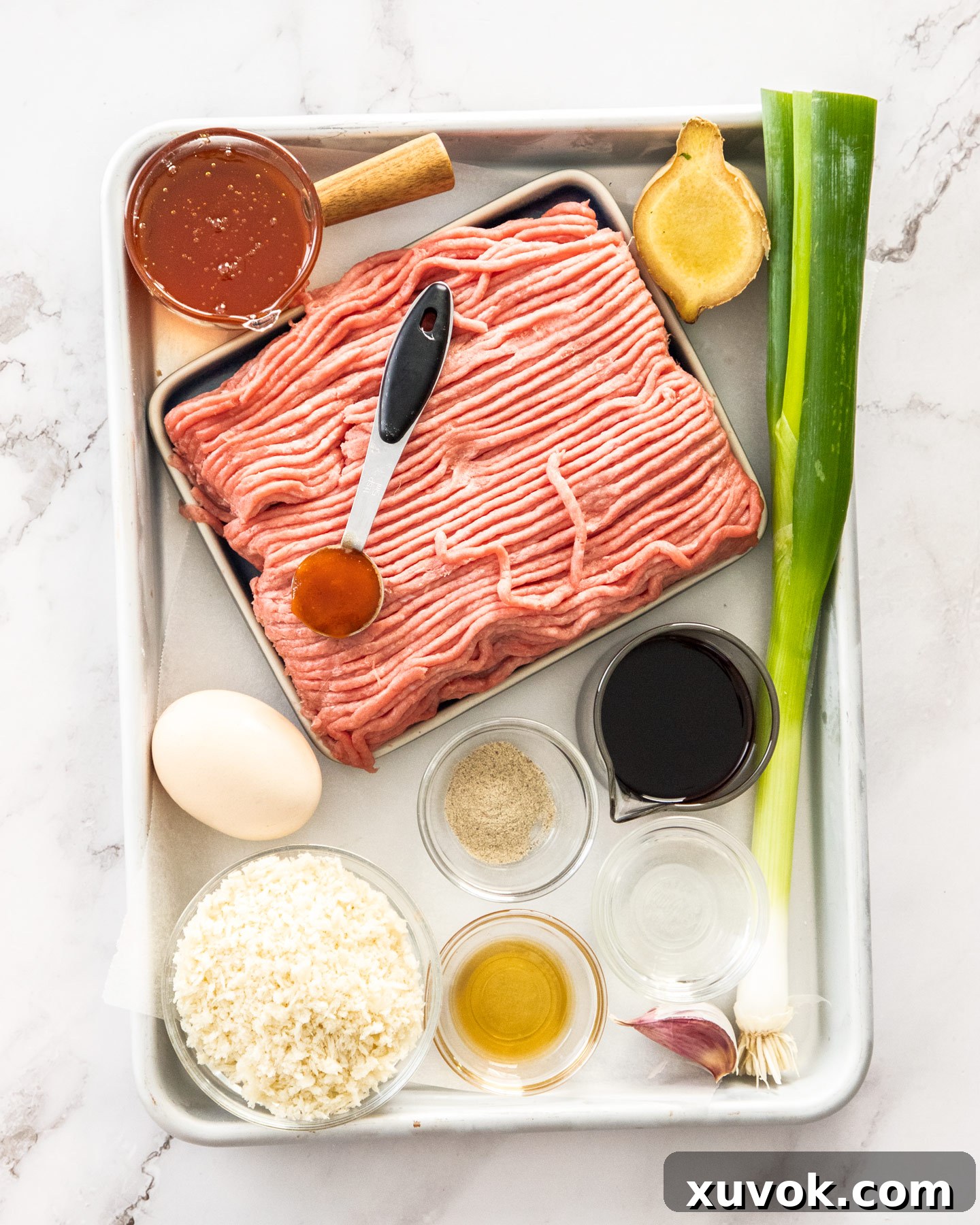 Ingredients for turkey rissoles on a baking tray.