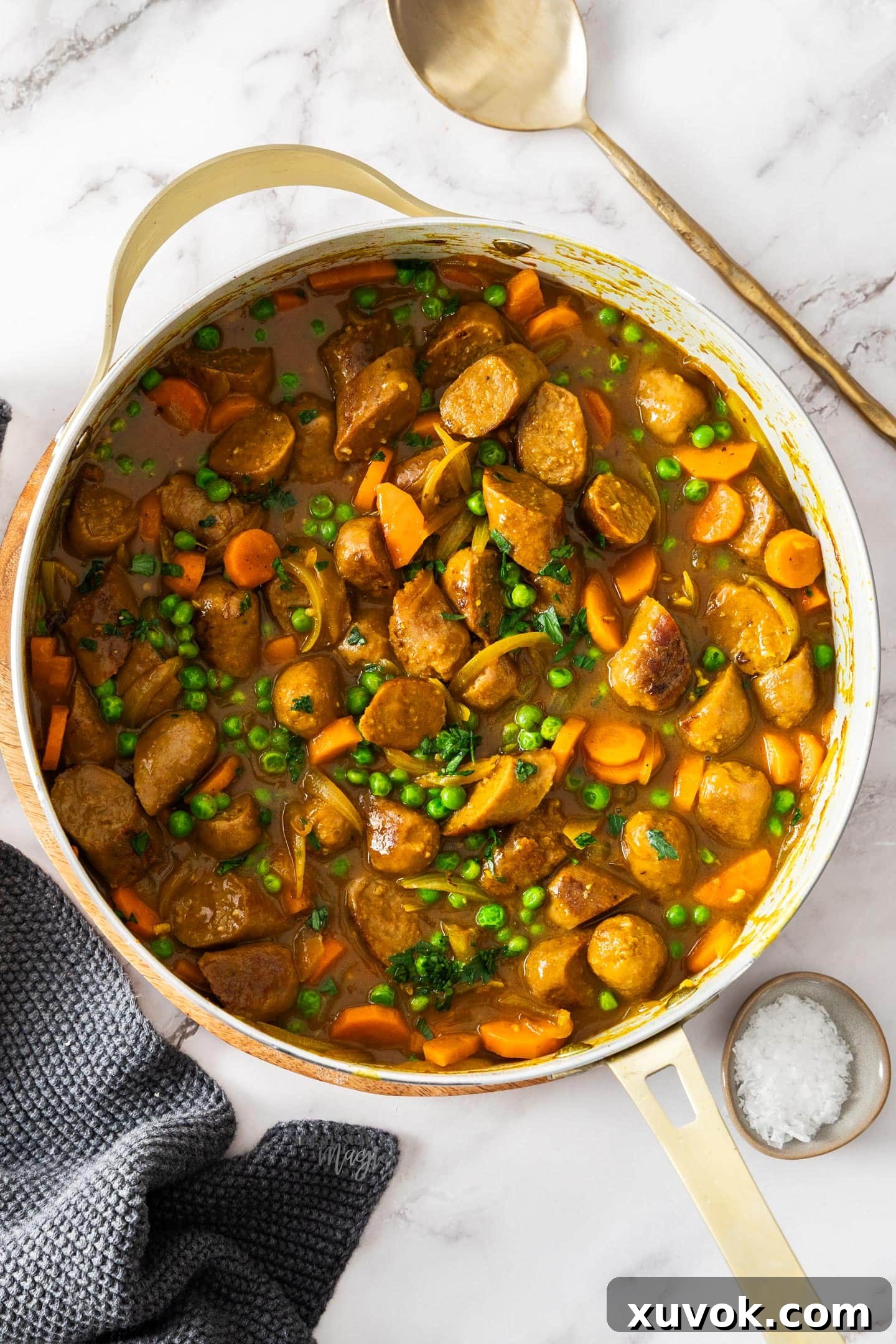 Top down view of a pan filled with curried sausages.