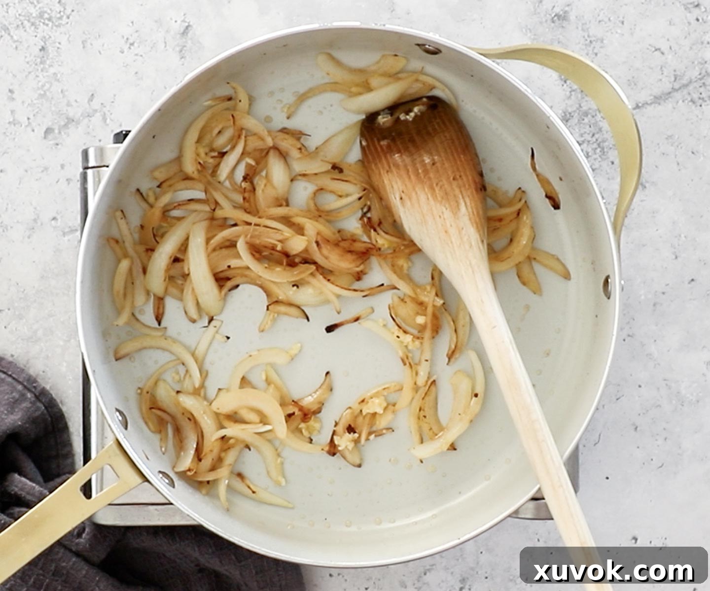 The onions being sauteed in a pan.