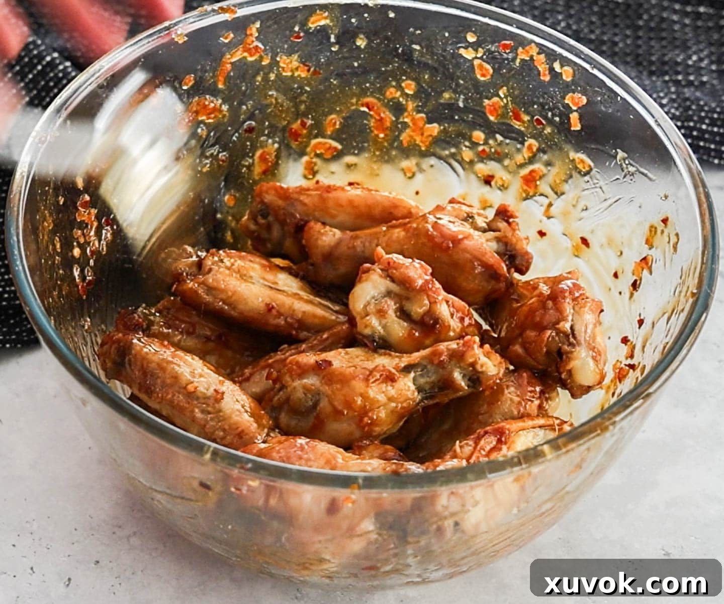 Crispy oven baked chicken wings in a bowl coated in the honey garlic glaze.