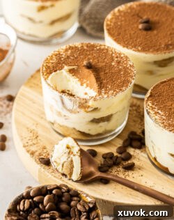 A tiramisu cup with a scoop taken out, revealing its creamy layers.