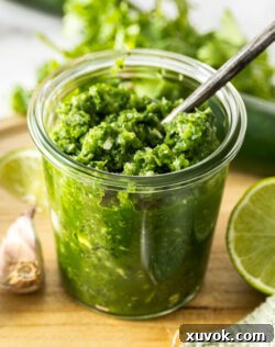Closeup of vibrant fresh jalapeno relish in a glass jar, showcasing its texture and color.