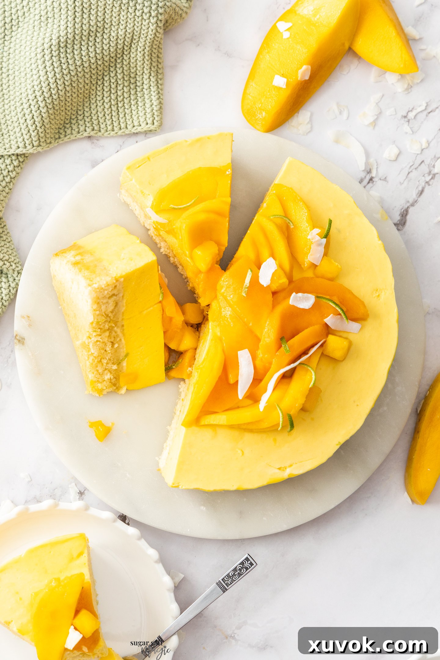 Top-down view of a beautifully sliced mango mousse cake on a platter, showcasing its layers.