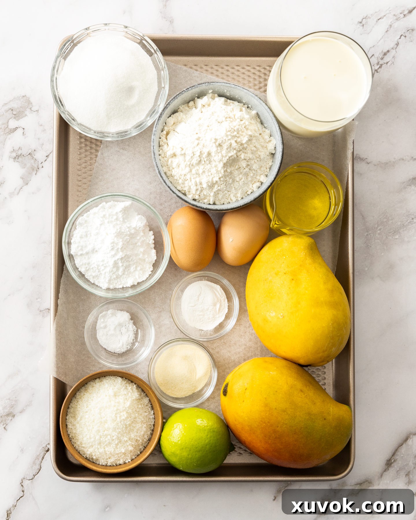 Assorted ingredients for mango mousse cake laid out on a baking tray.