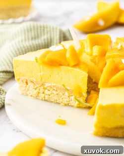 A sliced mango cake on a cake platter, revealing its layers.
