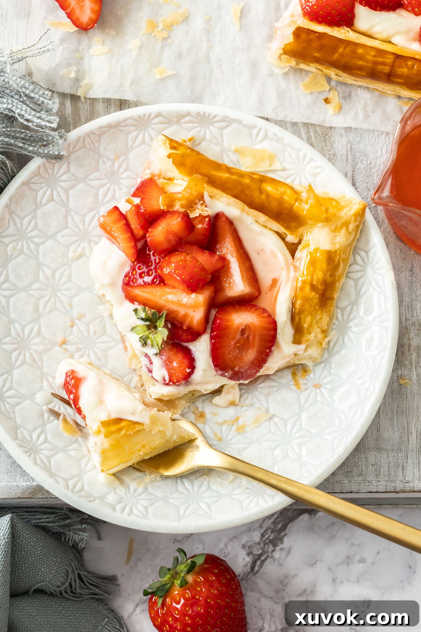 A slice of puff pastry tart with a piece on a fork.