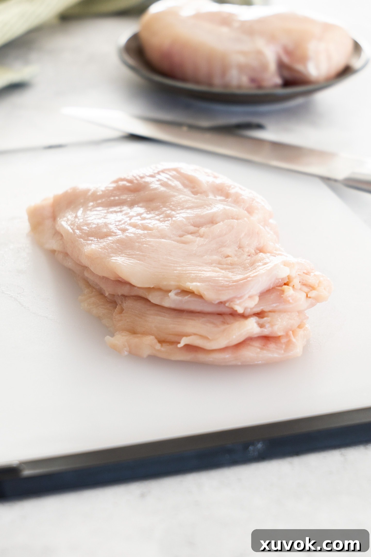Four perfectly cooked and stacked chicken cutlets, showcasing their tender texture and golden finish, ready to be served.