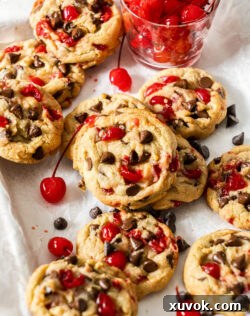 Closeup of the cookies with cherries dotted around them, highlighting the vibrant color.