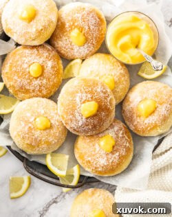 Top down view of lemon donuts on a metal tray.