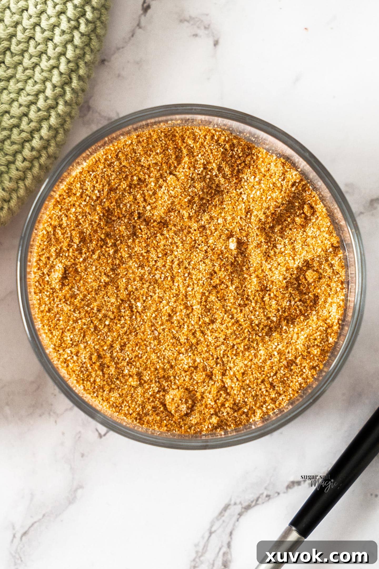 Top down view of a glass full of fajita seasoning, highlighting its rich color and texture.