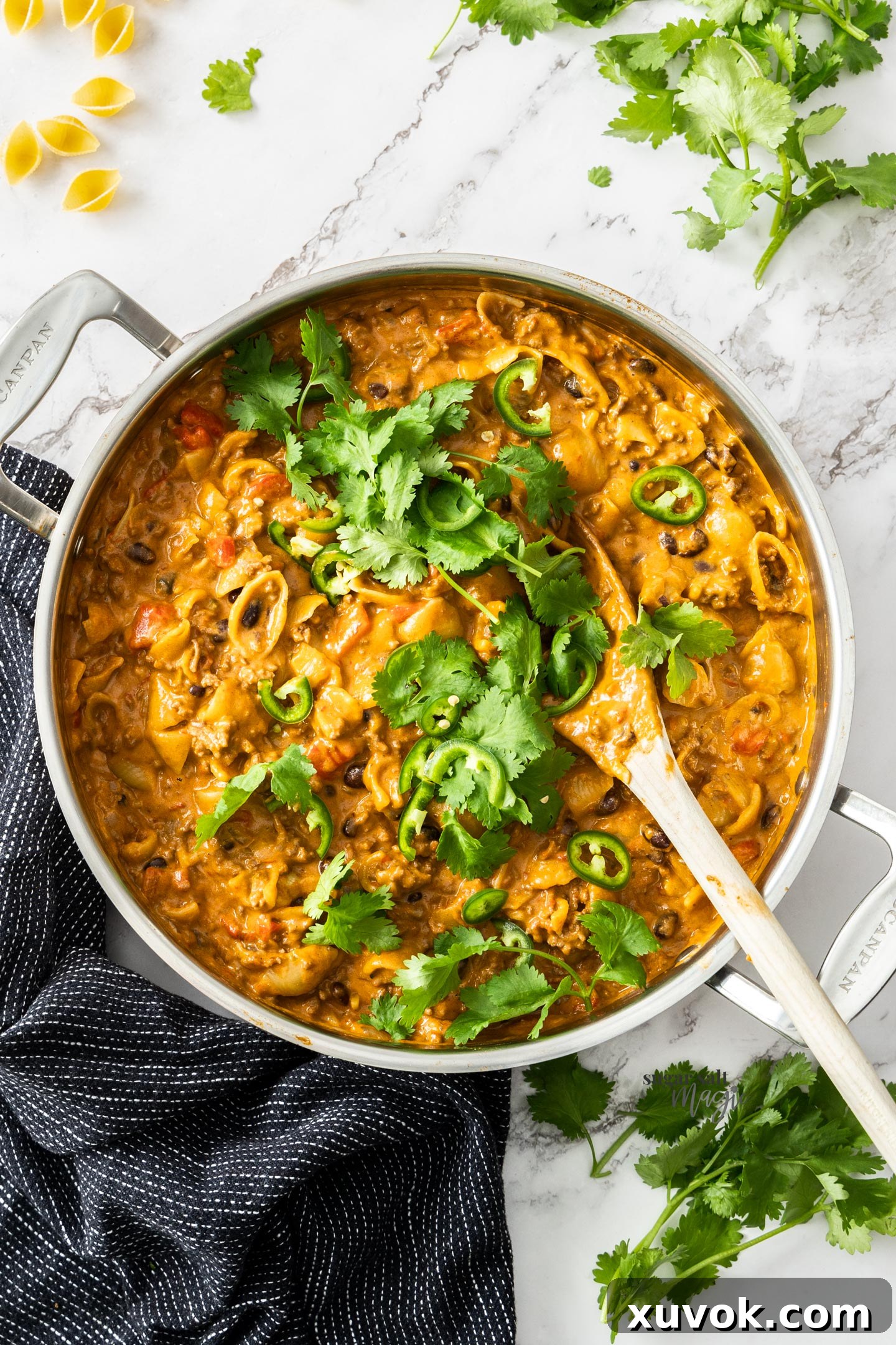 Taco pasta in a large pan topped with coriander and jalapenos.