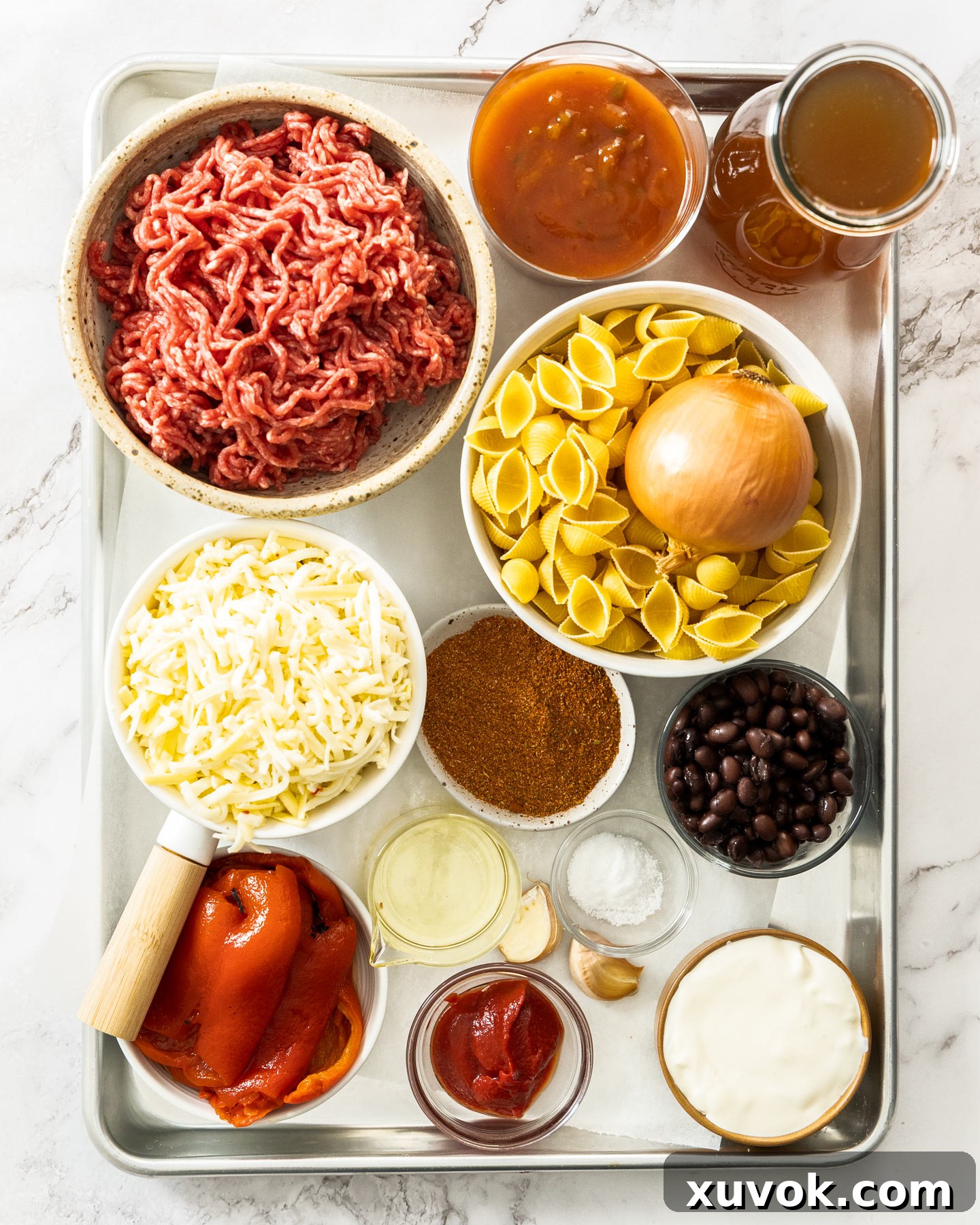 Ingredients for taco pasta on a baking tray.