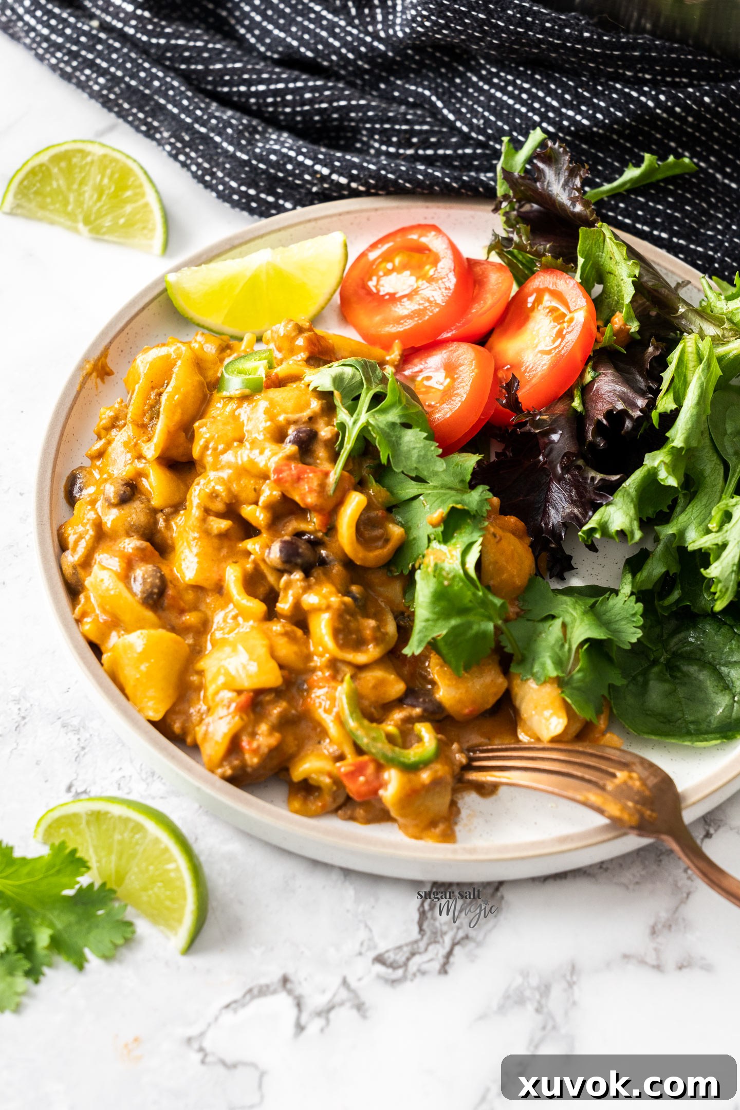 Taco pasta on a plate with salad.