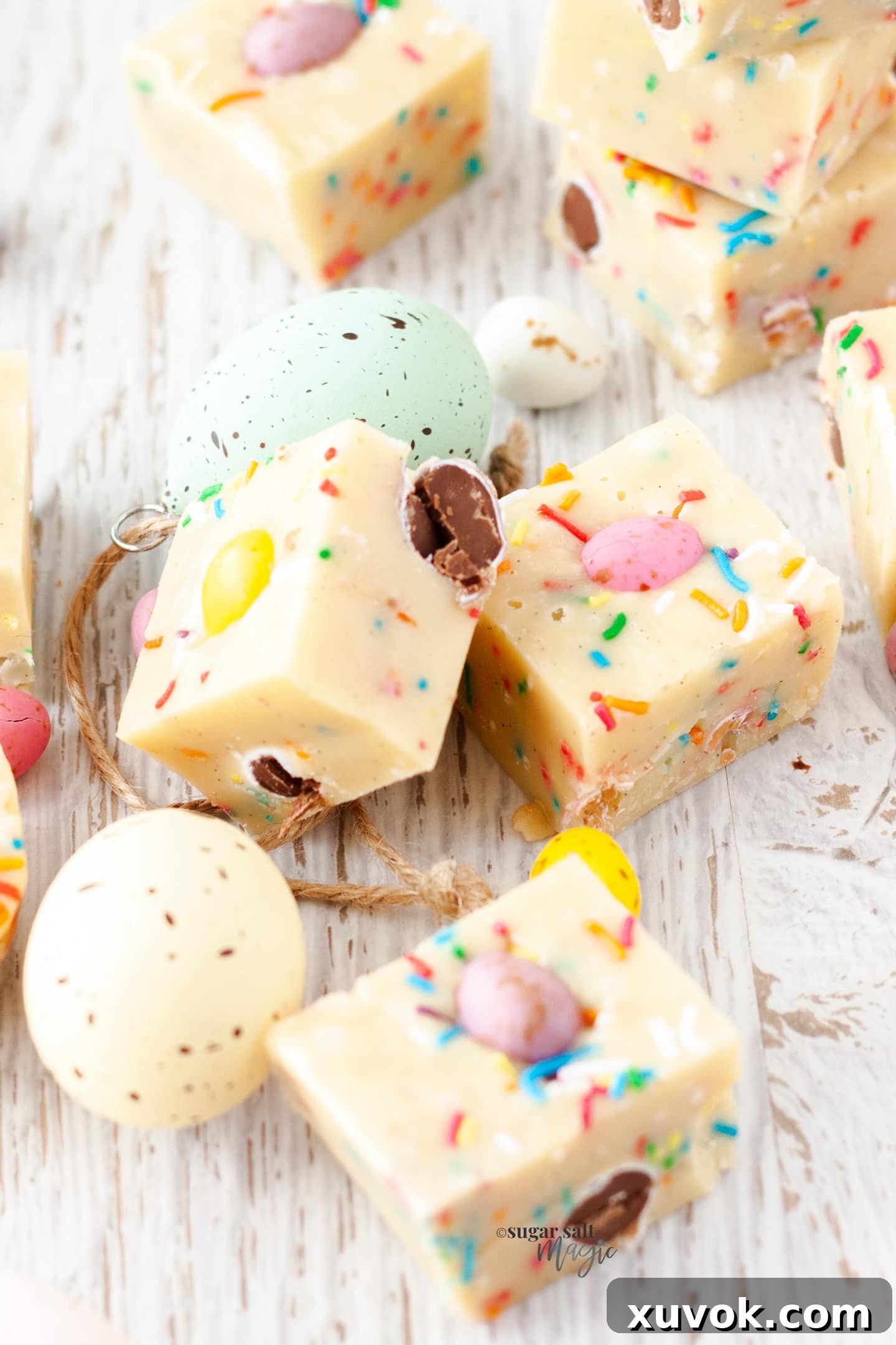 Squares of easter egg fudge surrounded by mini eggs, ready to be enjoyed.