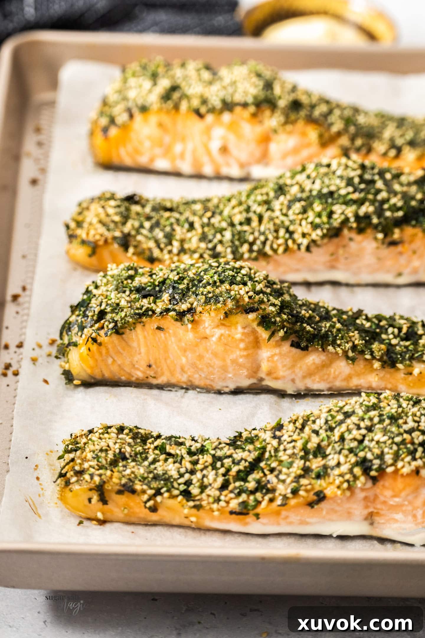 Four pieces of beautifully baked furikake salmon on a baking tray, showcasing the crispy, flavorful crust.