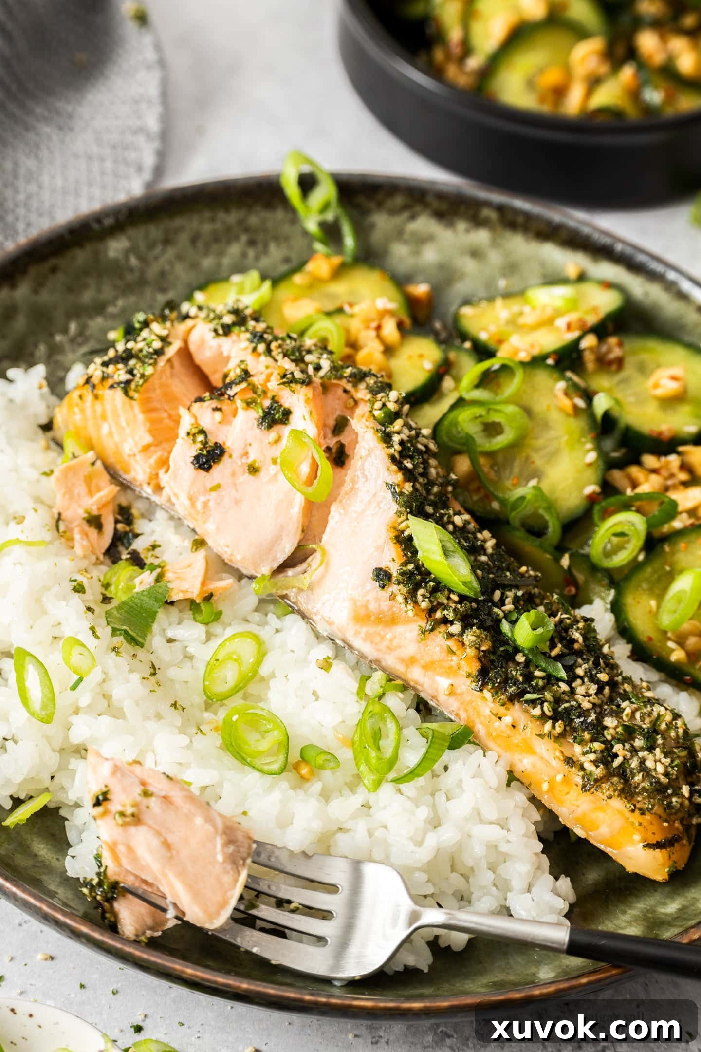 A close-up of a furikake salmon fillet broken open to reveal its tender, flaky, and moist flesh.