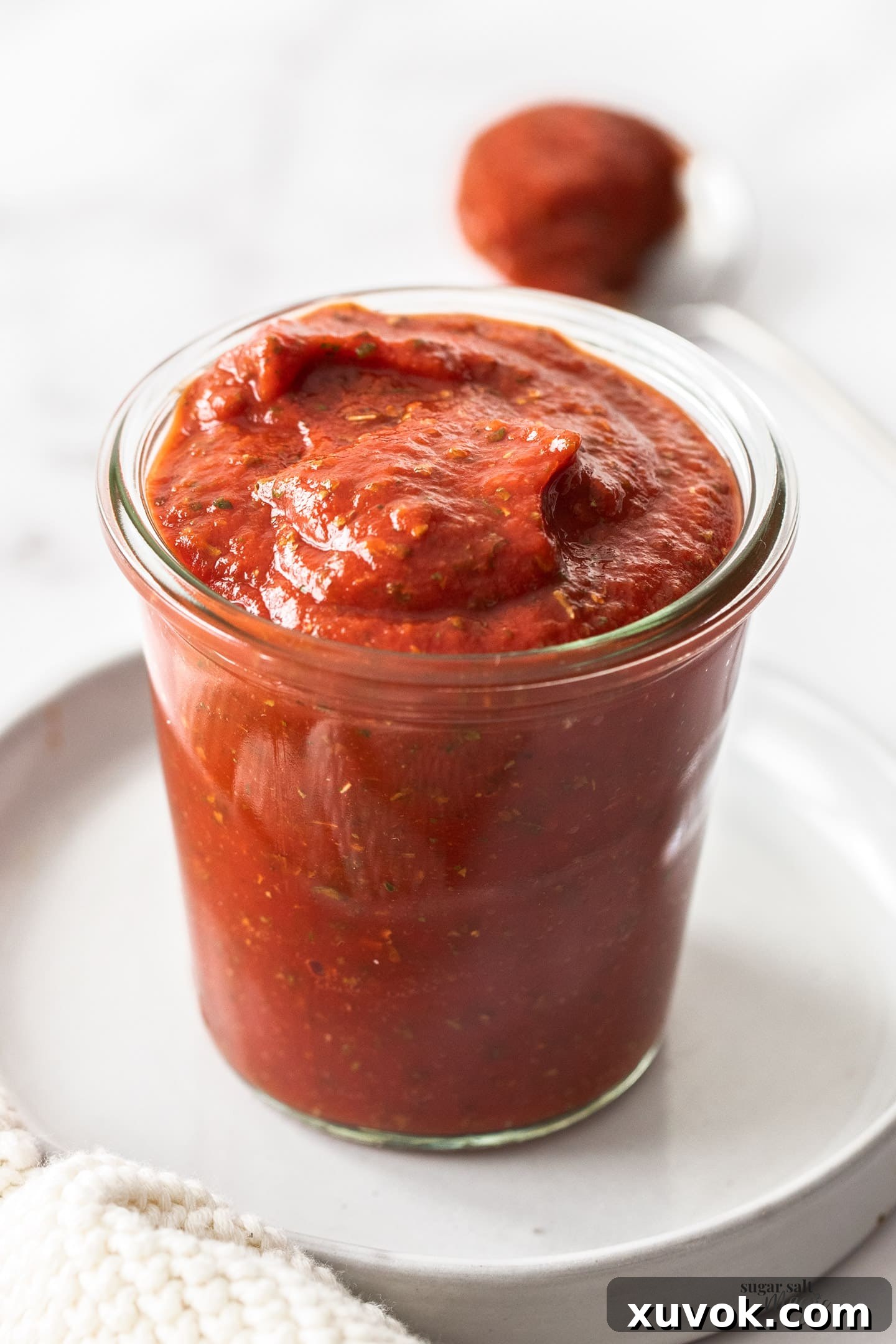 Pizza sauce in a glass jar.