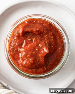 Closeup of pizza sauce in a glass jar.