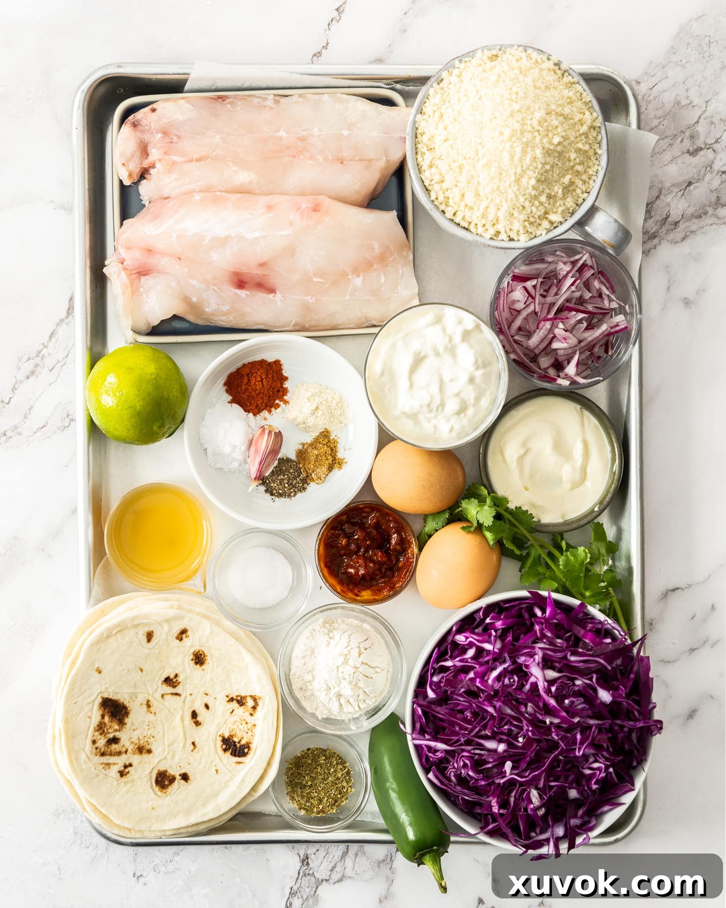 Ingredients for baja fish tacos on a baking sheet.