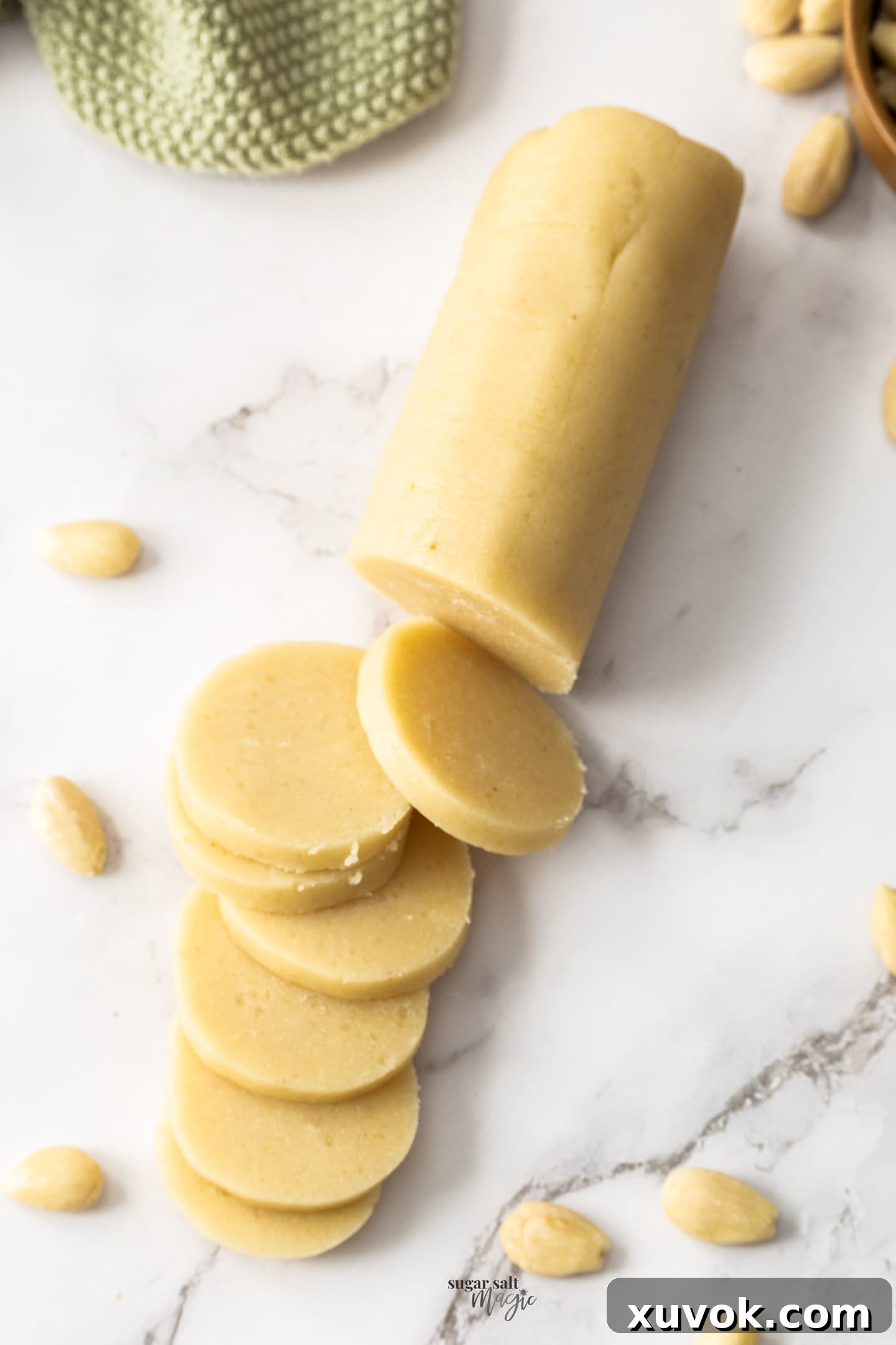 A log of almond paste cut into slices.