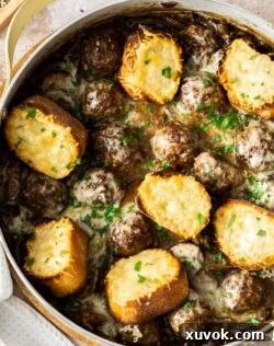 Meatballs and Gruyere croutons in a pan.