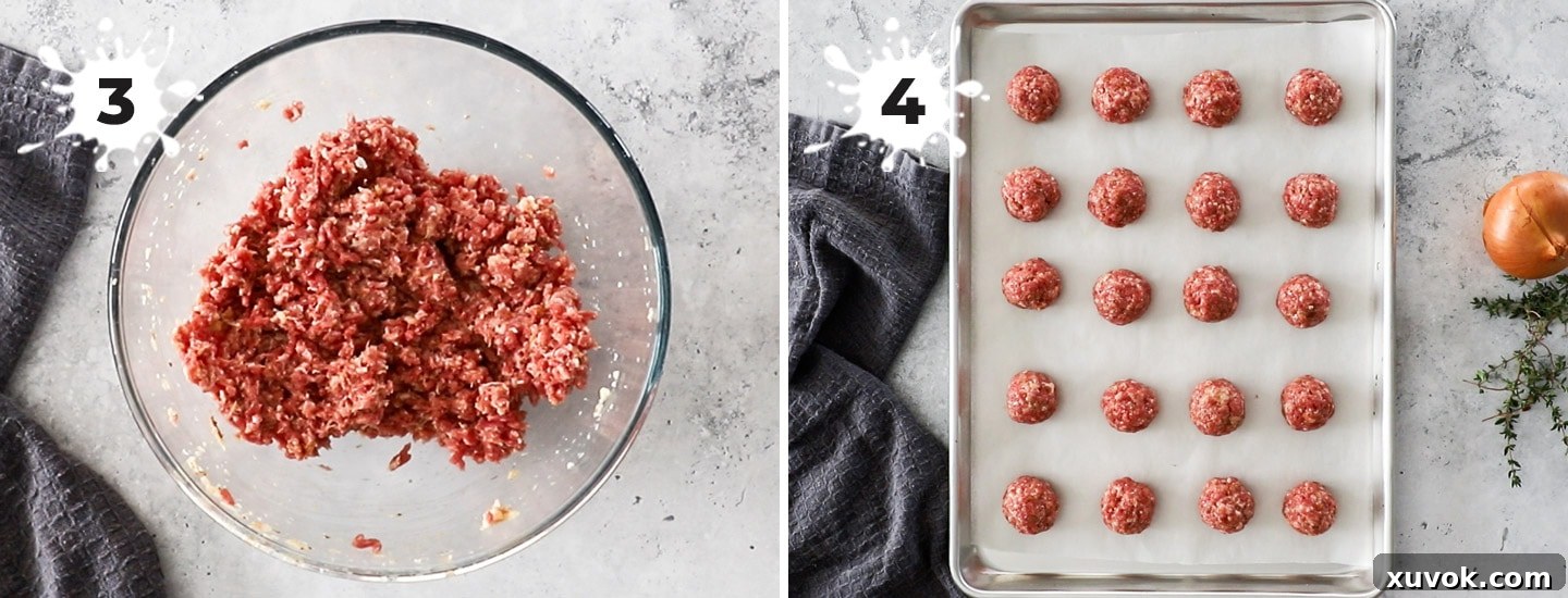 Raw, perfectly shaped meatballs arranged on a foil-lined baking sheet, ready for broiling.