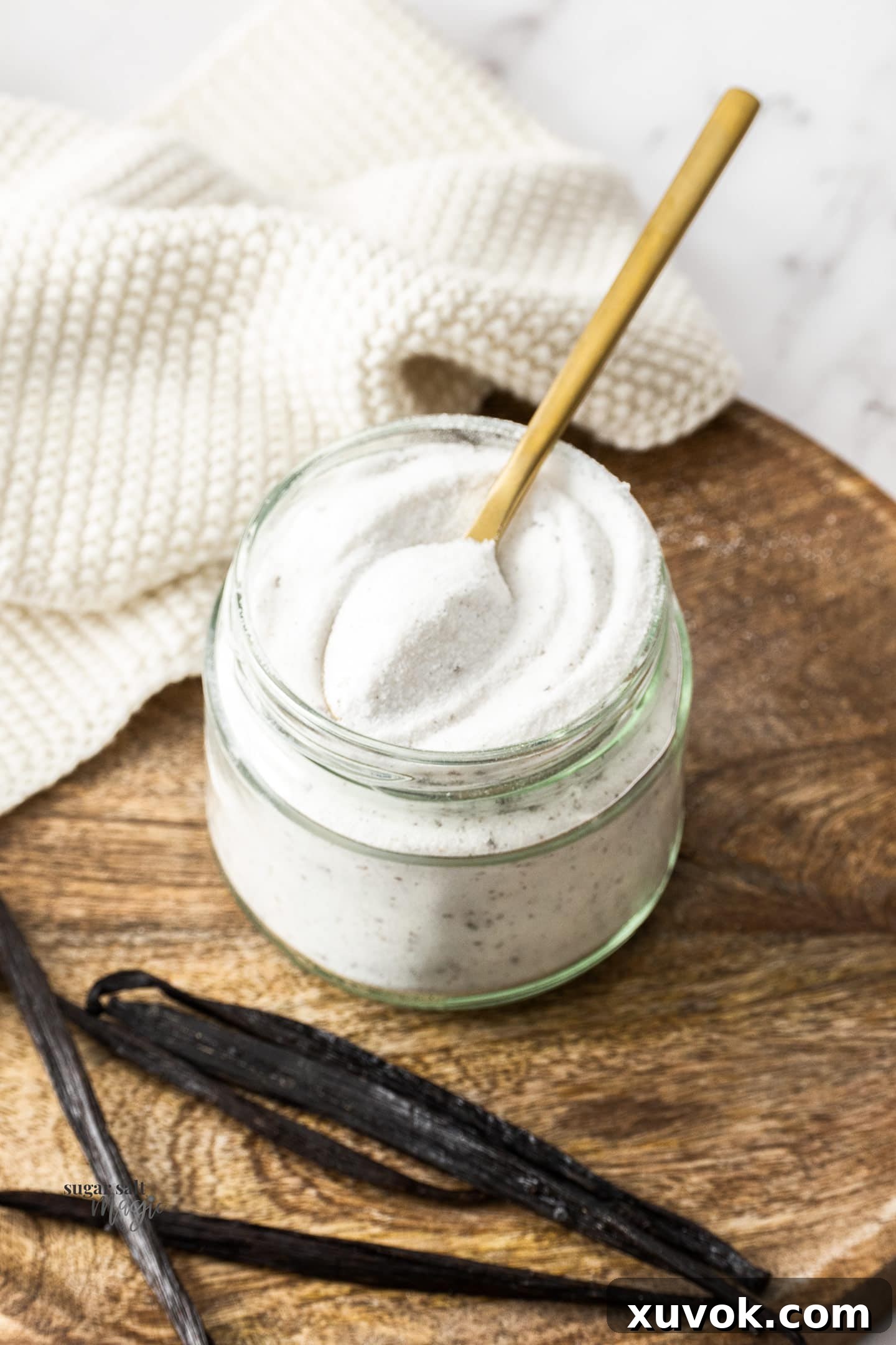 A jar of vanilla sugar with a spoon inserted, ready to be used.