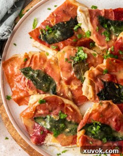 Slices of cooked prosciutto topped chicken on a plate, ready to serve.