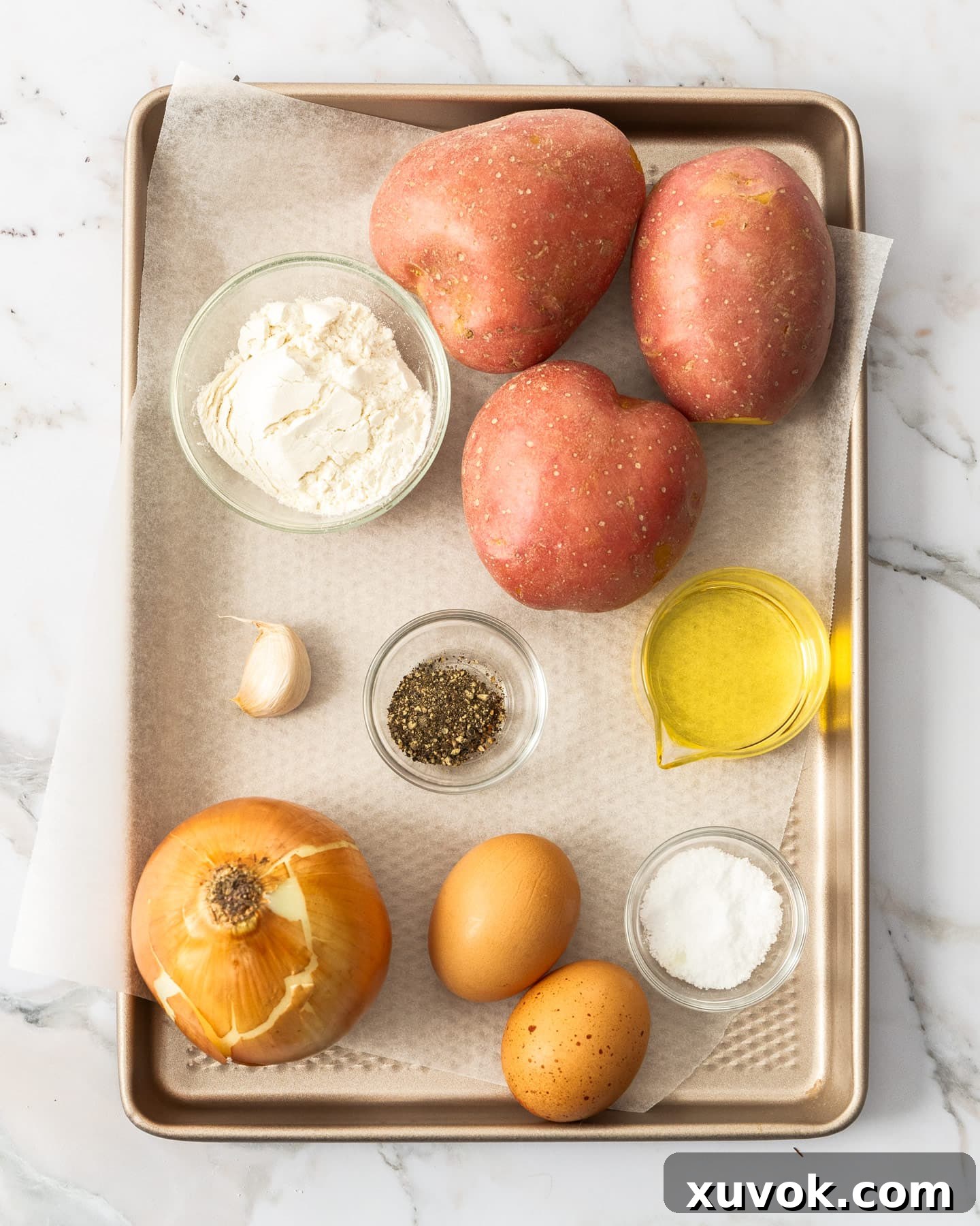 Fresh ingredients for making potato fritters laid out on a baking tray, ready for preparation.