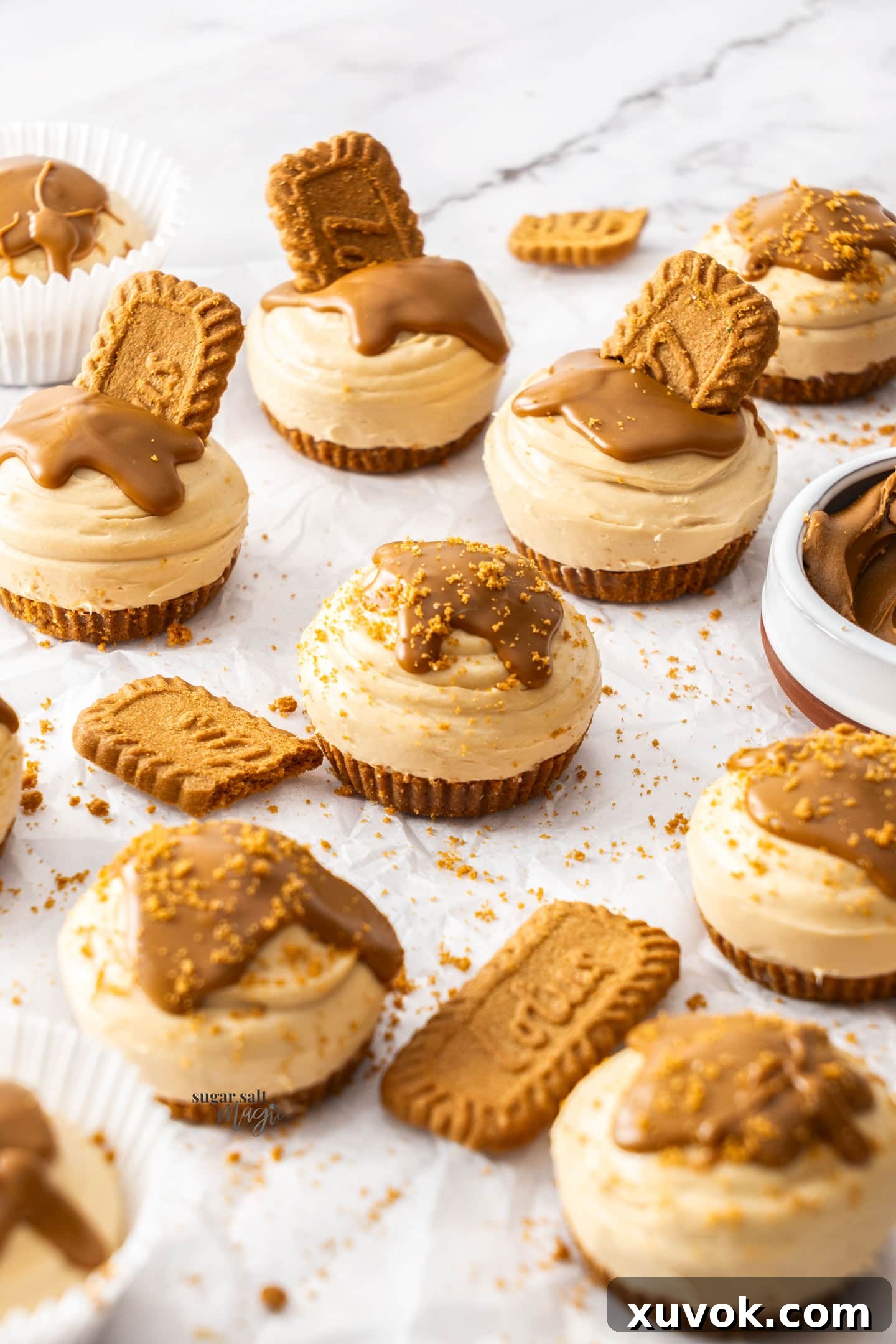 A batch of mini cheesecakes on a sheet of baking paper.