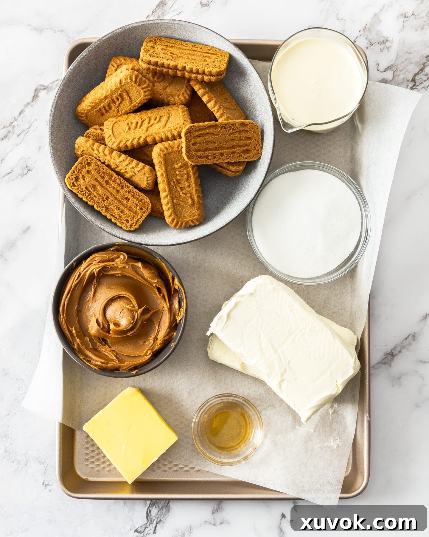 Ingredients for mini biscoff cheesecakes on a baking tray.