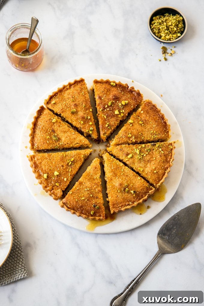 Birds-eye view of a beautifully cut Honey Baklava Tart with 8 slices, showcasing a golden crust, nutty filling, and a glistening syrup drizzle.