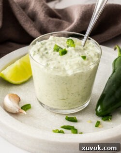 A glass filled with creamy homemade jalapeno mayo.