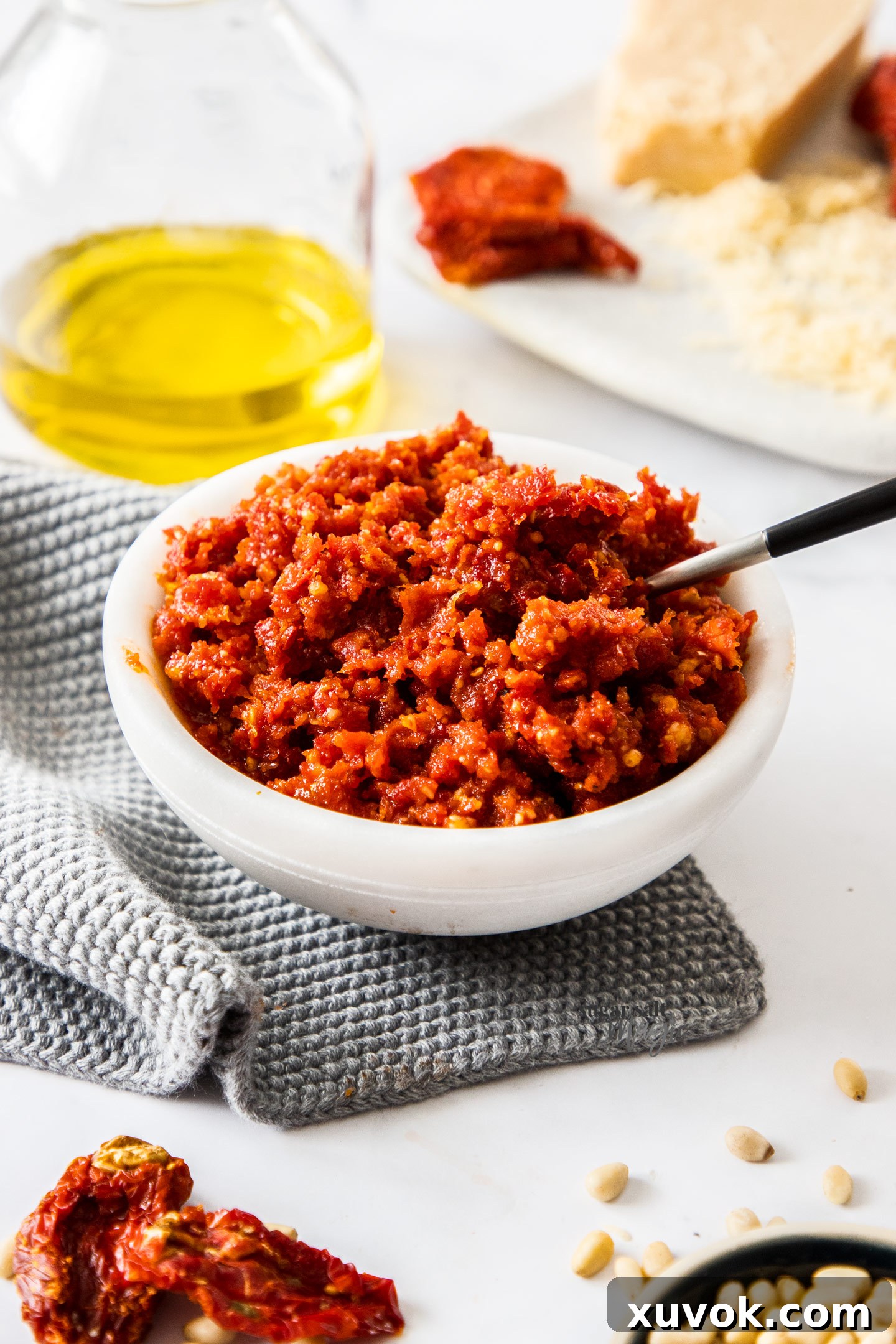 A marble bowl filled with vibrant red sun dried tomato pesto.
