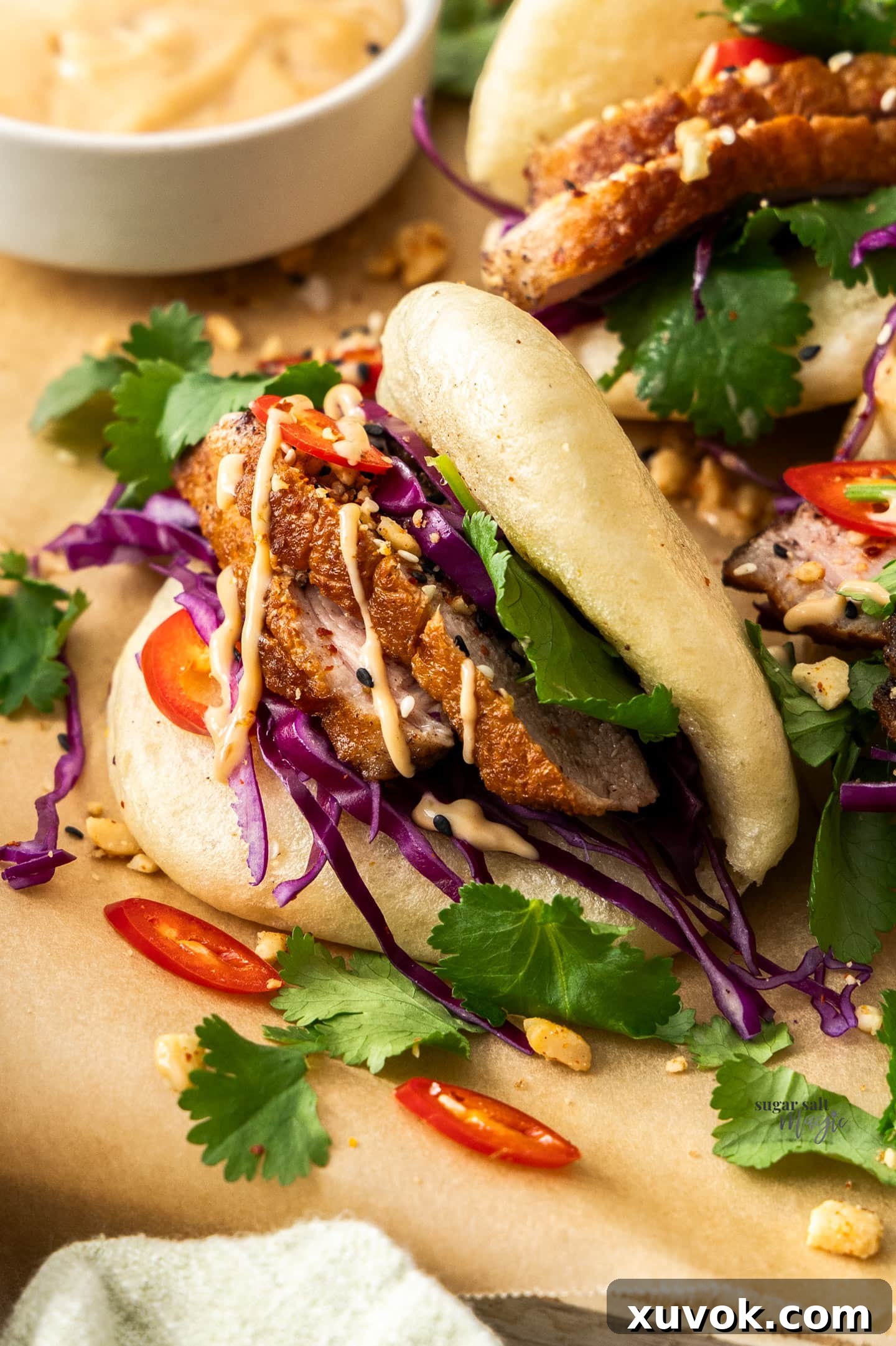 Closeup of a bao full of duck and vegetables.