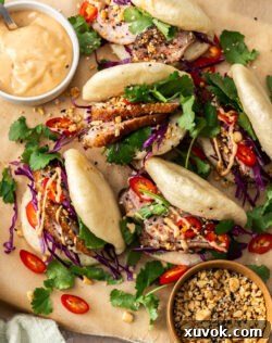 5 duck bao buns on a serving board.