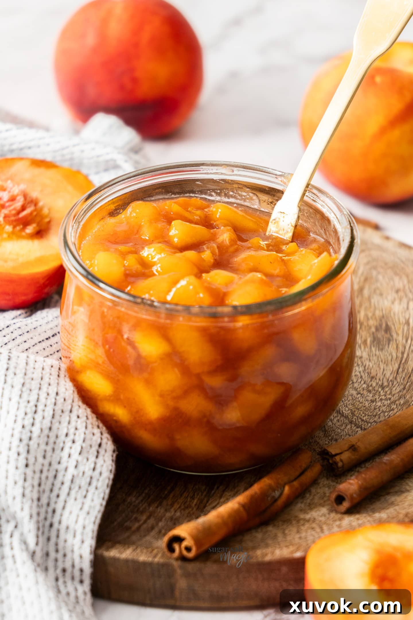 A glass jar filled with luscious peach compote, ready to be served.