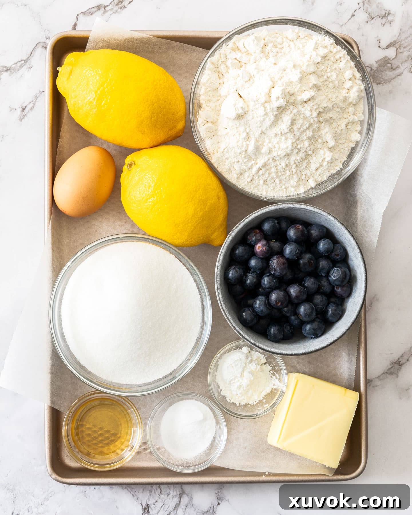 Ingredients for lemon blueberry cookies laid out on a baking tray.