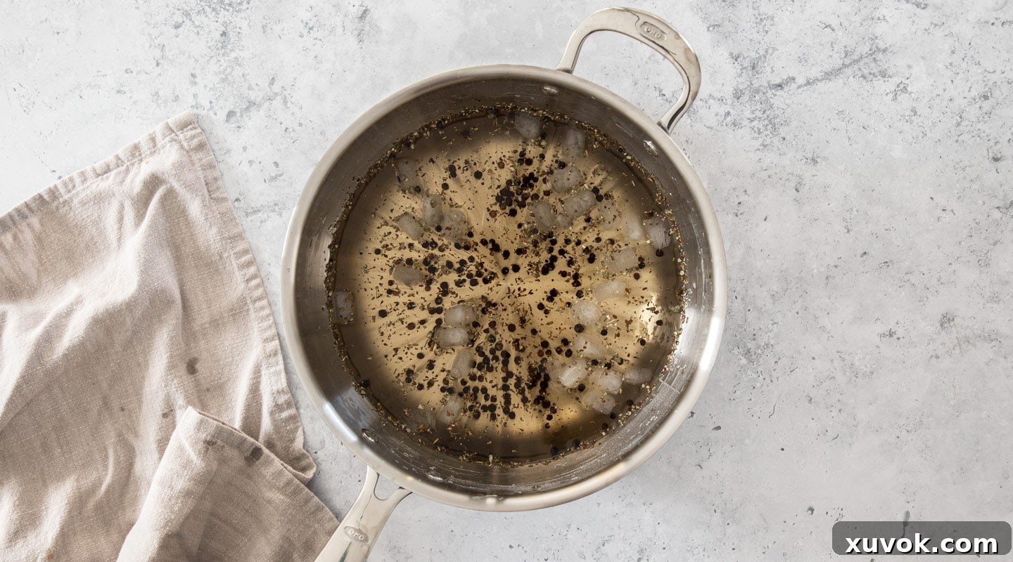 Ice cubes being carefully added to the hot brine mixture in a saucepan to rapidly cool it down.