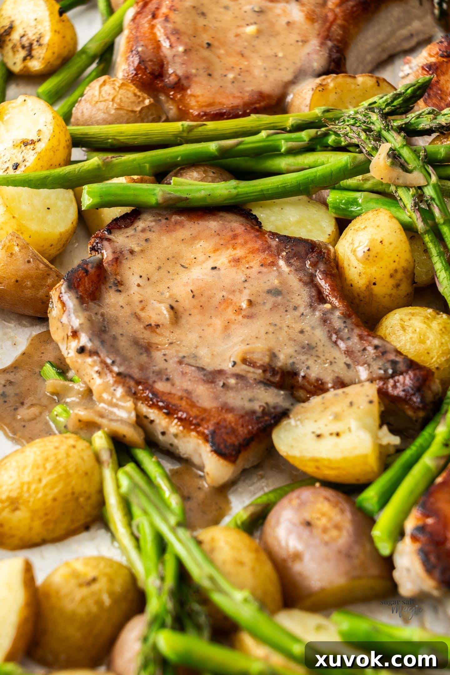 A single pork chop served with roasted potatoes and asparagus, generously drizzled with the sage-shallot sauce.