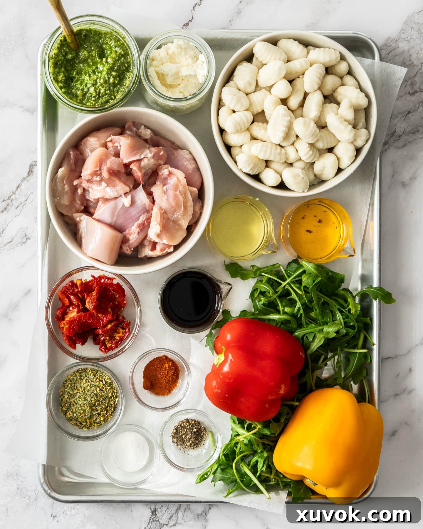 Ingredients for Italian chicken tray bake on a baking tray.