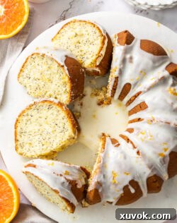 Top down view of an orange and poppy seed bundt cake with four slices cut, ready for serving.