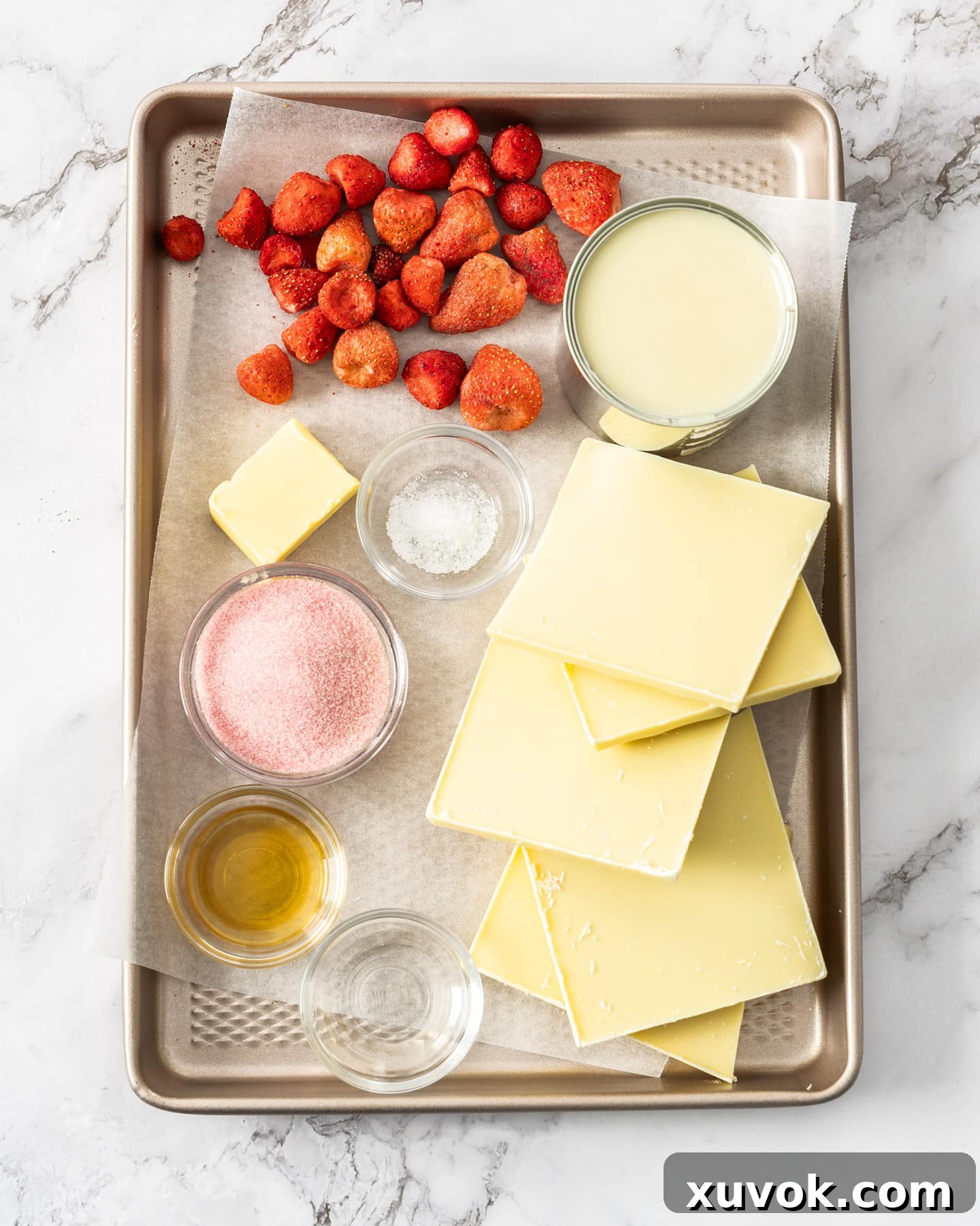 Assortment of fresh and packaged ingredients for strawberry fudge arranged on a baking tray.