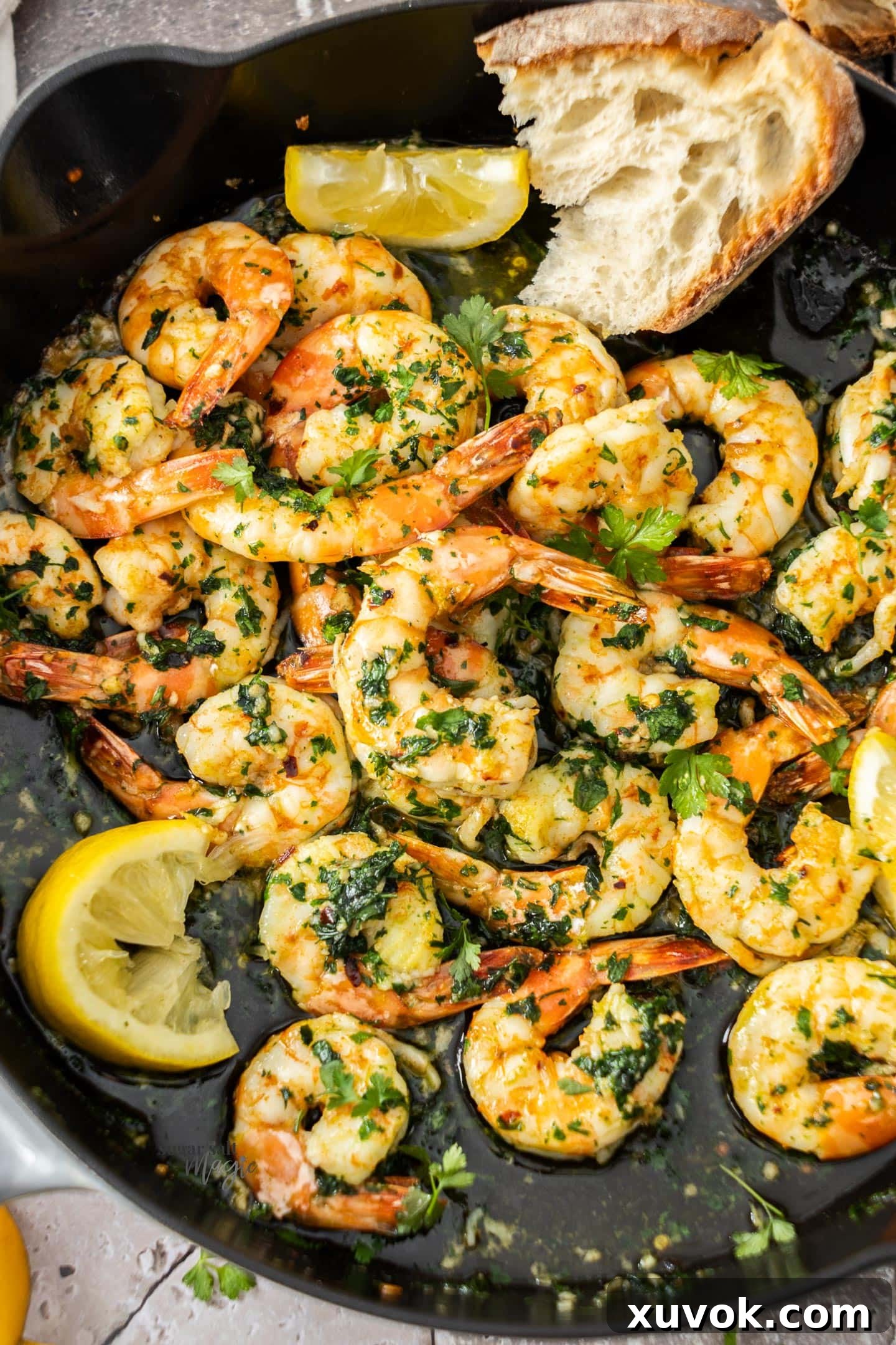 Top down view of cooked garlic prawns in a pan, ready to be served.