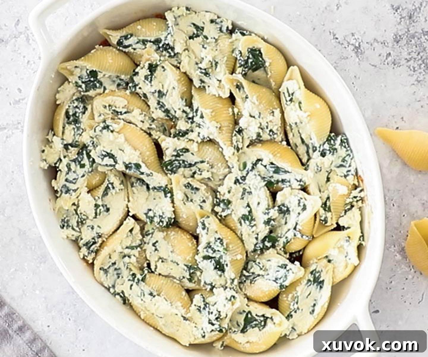 The ricotta filled pasta shells arranged in a baking dish.