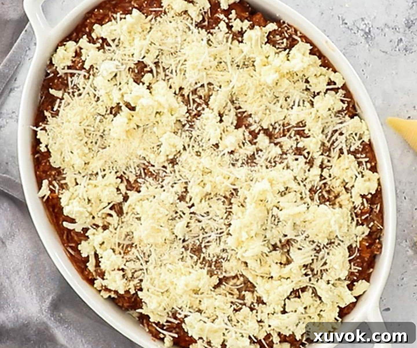 The dish topped with cheese, ready to bake.