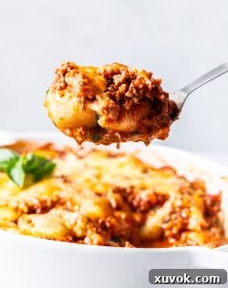 A scoop of lasagna stuffed shells on a spoon.