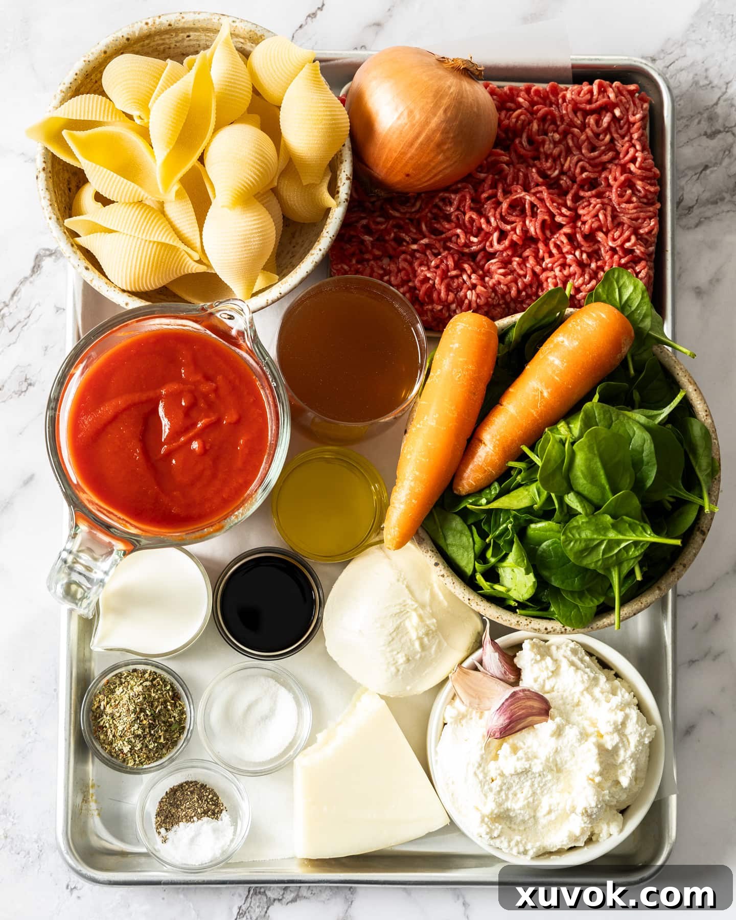 Ingredients for lasagna stuffed shells on a baking tray.