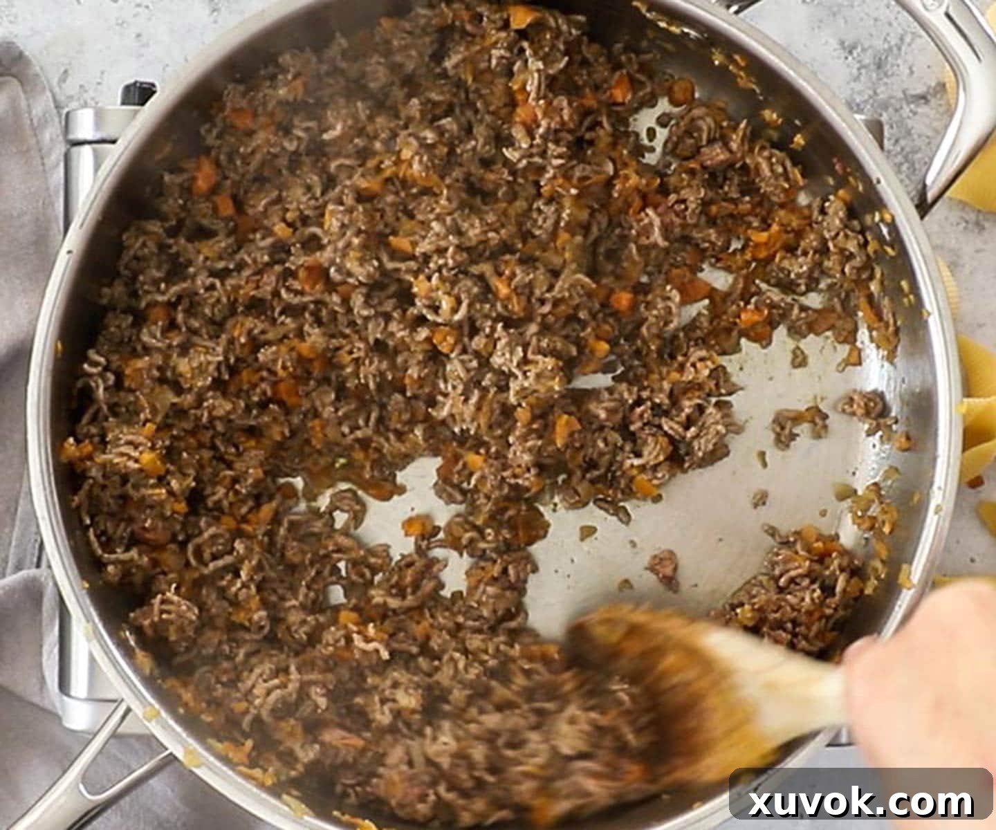 The ground beef in the pan, cooked until brown.