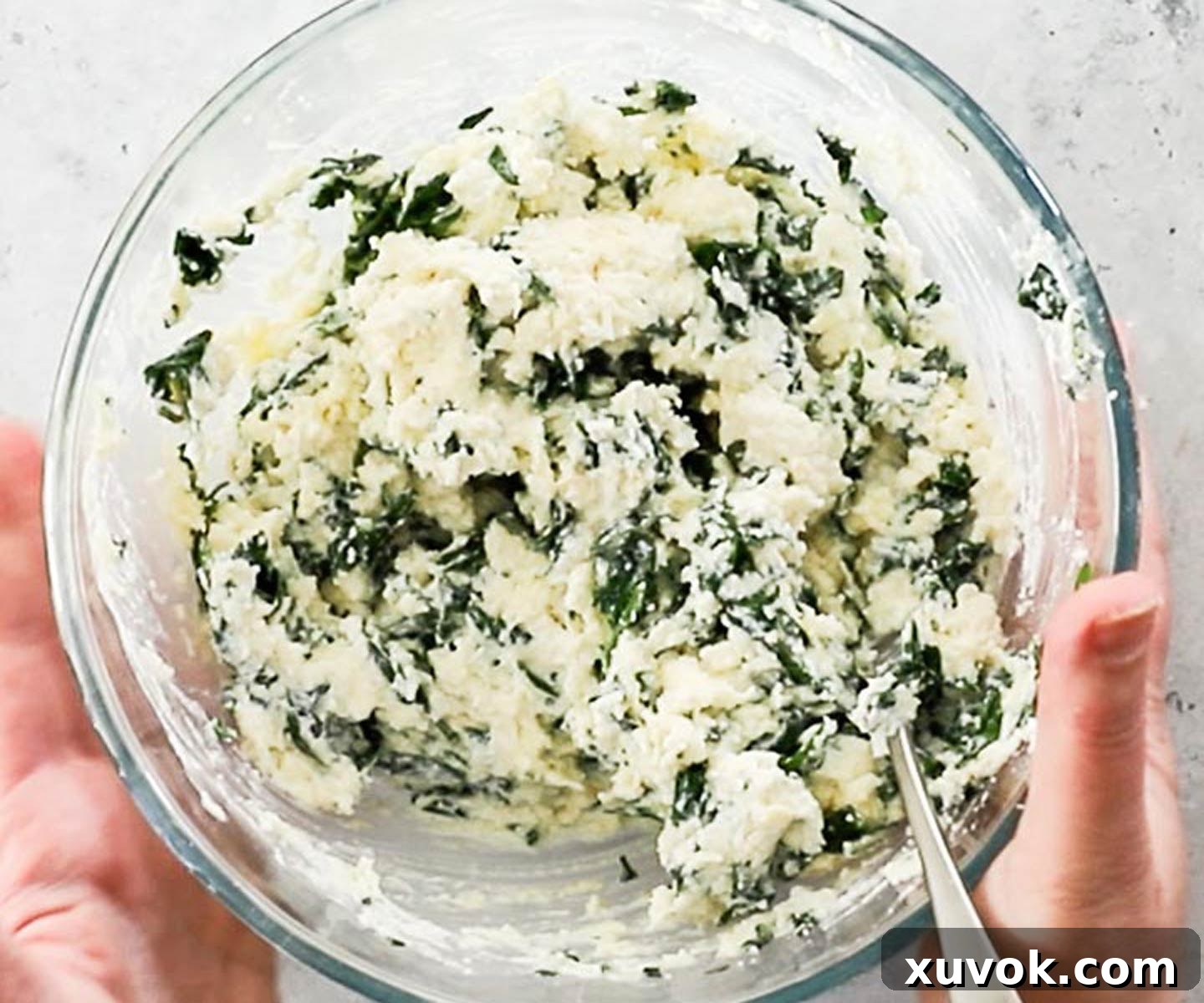 The ricotta and spinach filling for the stuffed shells in a mixing bowl.
